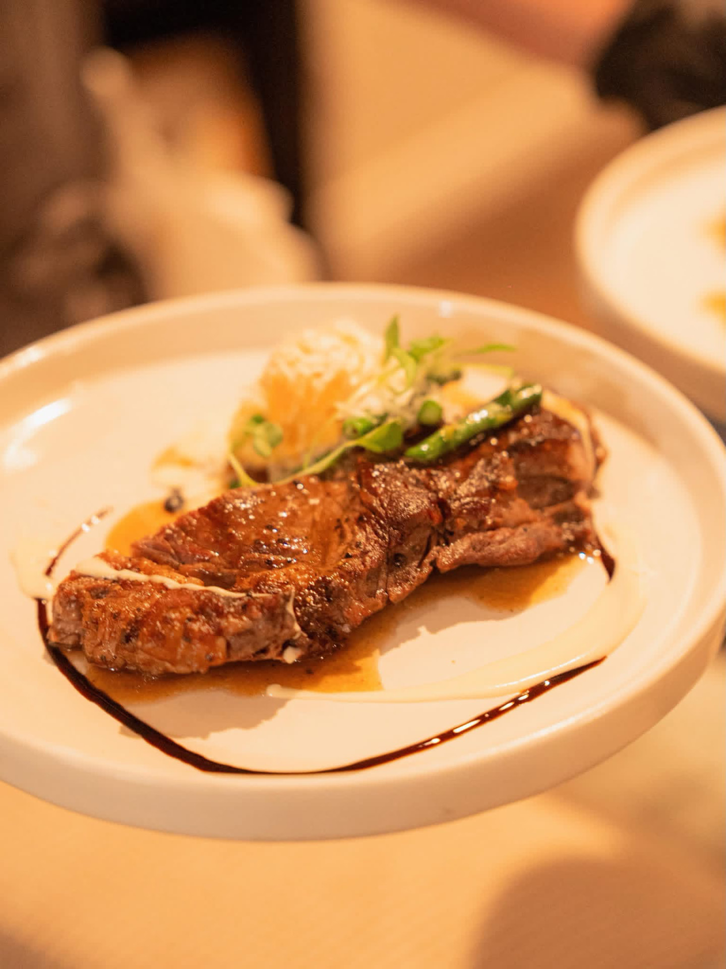 Grilled steak plated with fresh garnish